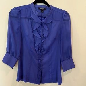 Ruffle front button down blouse with sheer fabric.